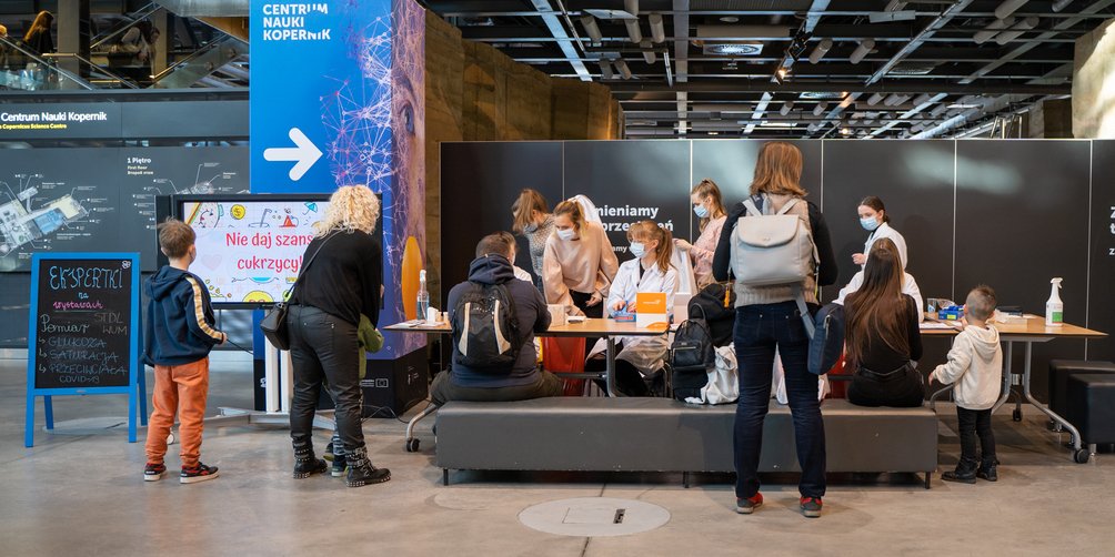 Prowadzący warsztaty mierzą różne parametry, ciśnienie, cholesterol, glukozę i rozmawiają o wynikach ze zwiedzającymi. 