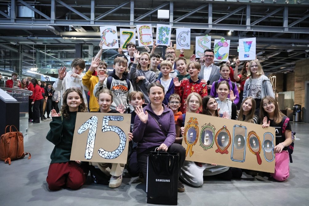 na zdjęciu dużo osób trzymających napis "15000000"