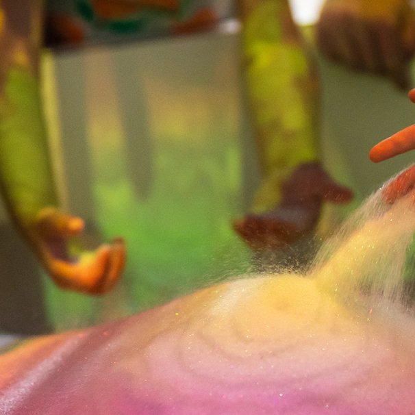 Widać ręce dzieci podświetlone przez eksponat "Usyp sobie ziemię".