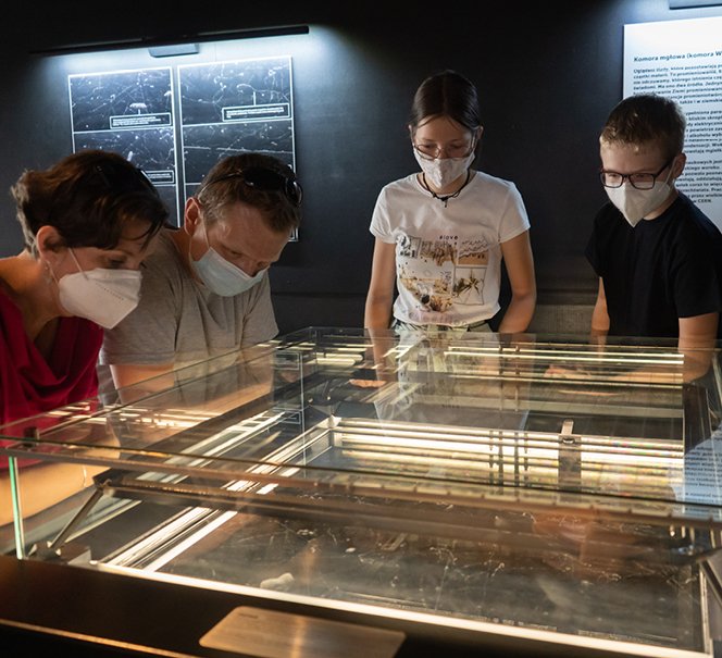 Dzieci z rodzicami przy eksponacie w Strefie Eksperymentowania