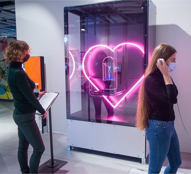 Dwie dziewczyny przy gablocie ze świecącym sercem.