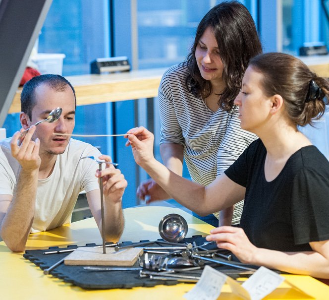 Troje ludzi przy stole warsztatowym