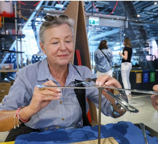 Starsza kobieta układa gwóźdź na drugim.